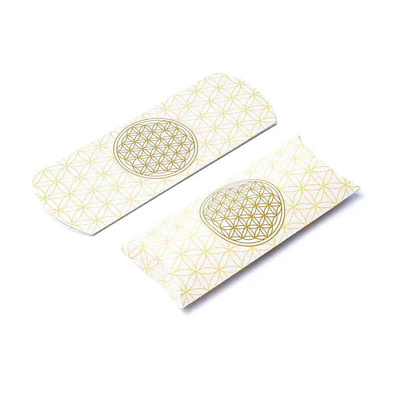 Aranyszínű ÉLET VIRÁGA motívummal díszített törtfehér, párna alakú papír doboz.